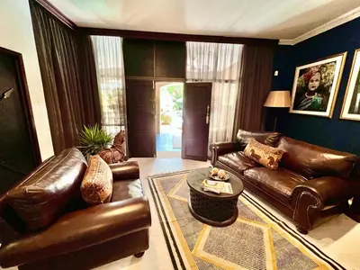 a living room with leather couches and a table at Forty 4 On Hoog in Polokwane