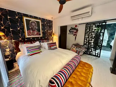 a bedroom with a large bed with colorful pillows at Forty 4 On Hoog in Polokwane