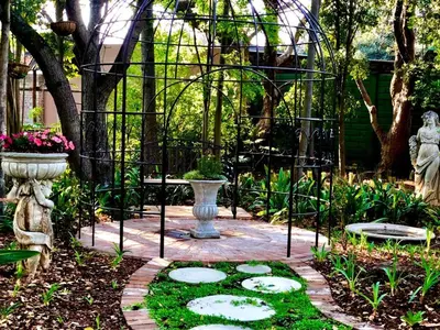 a garden with a stone path and a statue at Forty 4 On Hoog in Polokwane