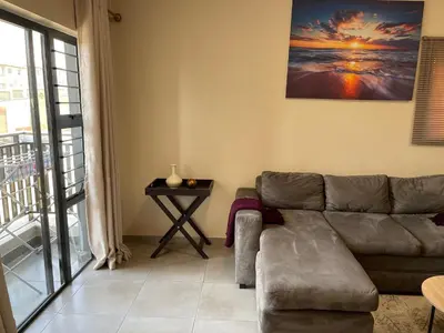 a living room with a couch and a table at Mall of Africa Spot By Damo in Midrand