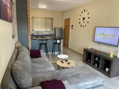 a living room with a couch and a tv at Mall of Africa Spot By Damo in Midrand