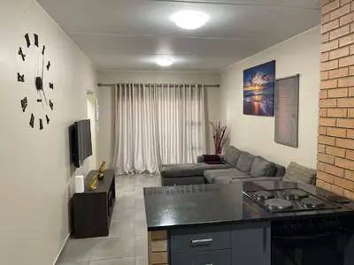 a kitchen and living room with a couch and a table at Mall of Africa Spot By Damo in Midrand