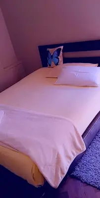 a bedroom with a white bed with a butterfly pillow at Thully Teams in Nelspruit