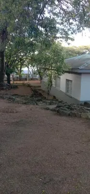 a white building with trees in front of it at Thully Teams in Nelspruit