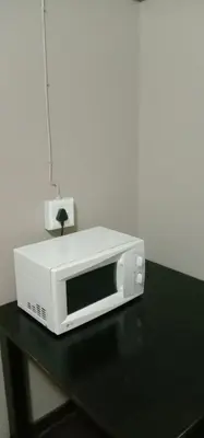 a microwave sitting on top of a black table at Thully Teams in Nelspruit