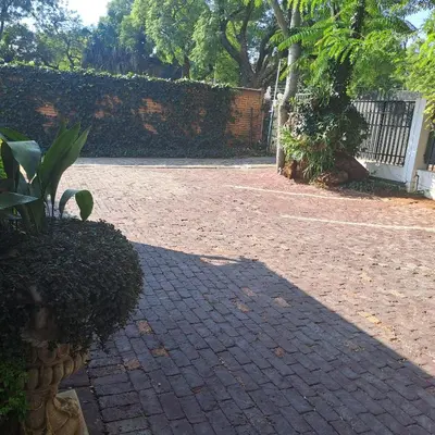 a shadow of a person on a brick driveway at Moonlight Guesthouse in Pretoria