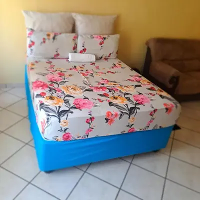 a bed with a blue frame with flowers on it at Moonlight Guesthouse in Pretoria