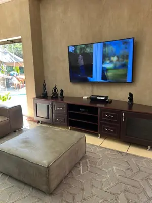 a living room with a large entertainment center with a flat screen tv at Pecanwood Lake View in Hartbeespoort