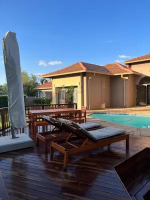 a deck with chaise lounges and a swimming pool at Pecanwood Lake View in Hartbeespoort