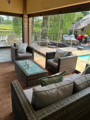 a patio with couches and a table and a pool at Pecanwood Lake View in Hartbeespoort