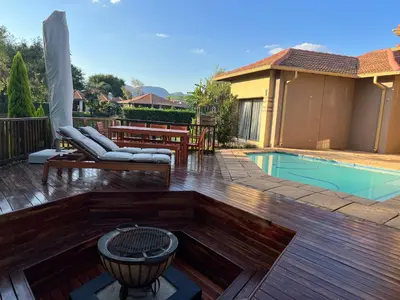 a backyard with a pool and a deck with a fire pit at Pecanwood Lake View in Hartbeespoort