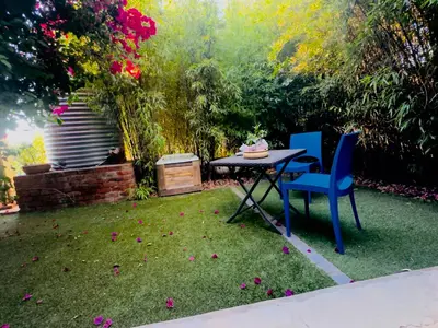 a garden with a table and chairs in the grass at Soul Oasis Urban Retreat in Centurion