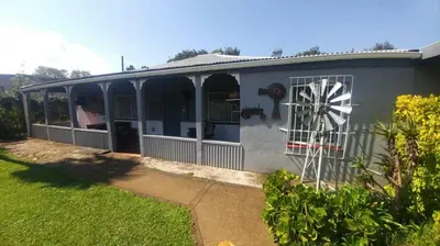 a house with a windmill on the side of it at Four Seasons Self-Catering Guest House in Graskop