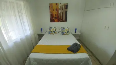 a small bedroom with a bed with a yellow blanket at Four Seasons Self-Catering Guest House in Graskop