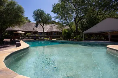 a large swimming pool in front of a house at MILIMA Big 5 Safari Lodge in Hoedspruit