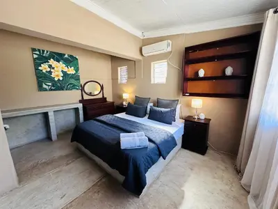 a bedroom with a bed with a blue comforter at 49onMain Self Catering Holiday Home in Sabie