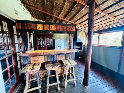 a bar in a restaurant with stools around it at 49onMain Self Catering Holiday Home in Sabie