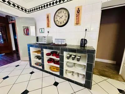 a clock on the wall above a counter with shoes at 49onMain Self Catering Holiday Home in Sabie