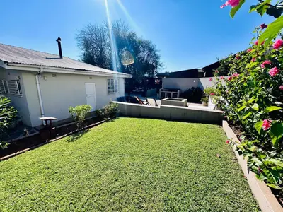 a backyard with a lawn and a house at 49onMain Self Catering Holiday Home in Sabie