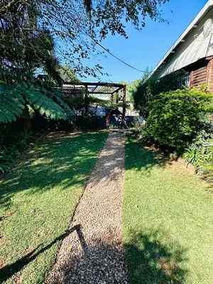 a walkway in the grass next to a building at 49onMain Self Catering Holiday Home in Sabie