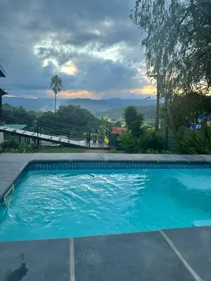 a swimming pool with blue water in a yard at 49onMain Self Catering Holiday Home in Sabie