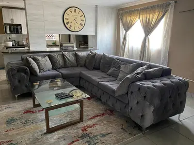 a living room with a leather couch and a table at RCB guesthouse in Burgersfort