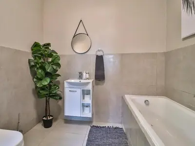 a bathroom with a sink and a tub and a plant at Featherwood Farm & Nyala Lodge in Rayton