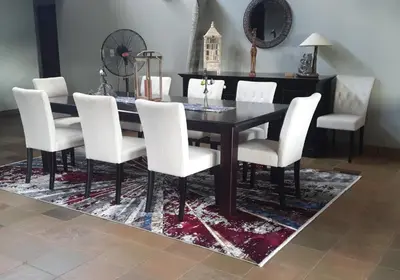 a dining room with a black table and white chairs at 113 Zwartkloof Private Game Reserve Bela-Bela in Bela-Bela