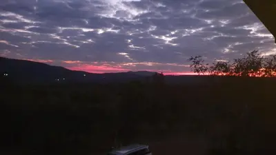 a view of a sunset from the window of a house at 113 Zwartkloof Private Game Reserve Bela-Bela in Bela-Bela