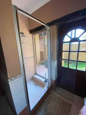 a bathroom with a shower and a glass door at Vintage Serene Villa in Hartbeespoort