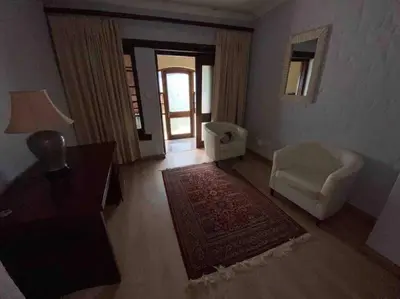 a living room with a chair and a table at Vintage Serene Villa in Hartbeespoort