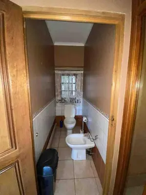 a small bathroom with a toilet and a sink at Vintage Serene Villa in Hartbeespoort
