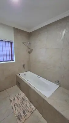 a large bathroom with a tub and a rug at Mafini Villa in Centurion