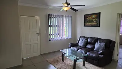 a living room with a couch and a glass table at Mafini Villa in Centurion
