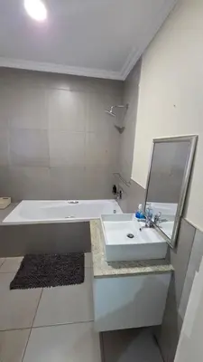 a bathroom with a sink and a tub and a mirror at Mafini Villa in Centurion