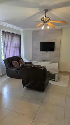 a living room with a couch and a flat screen tv at Mafini Villa in Centurion