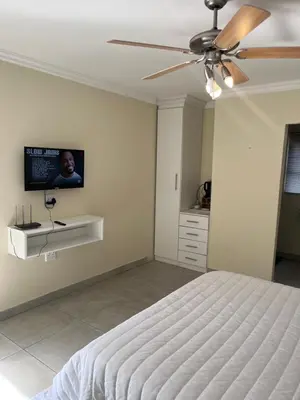 a bedroom with a bed and a ceiling fan at Mafini Villa in Centurion
