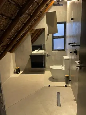 a bathroom with a sink and a toilet and a window at Tadima Lodge Mabalingwe in Mabula