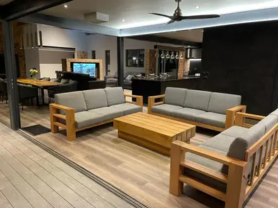 a living room with couches and a piano at Tadima Lodge Mabalingwe in Mabula