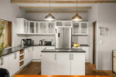a kitchen with white cabinets and a refrigerator at Elements Private Golf Reserve House 296 in Bela-Bela