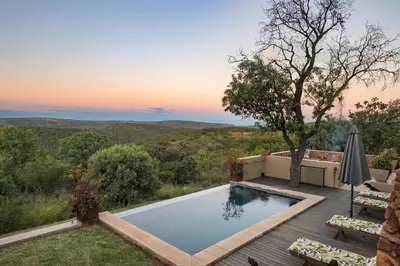 a pool on a deck with a view of the mountains at Elements Private Golf Reserve House 296 in Bela-Bela