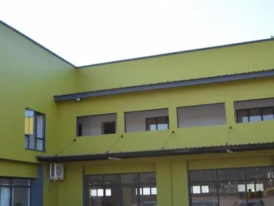 a yellow building with windows on the side at The Pickle Residence in Tzaneen