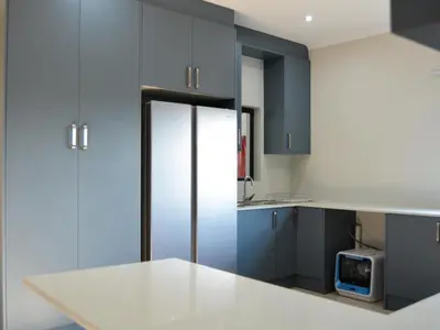 a kitchen with blue cabinets and a refrigerator at The Pickle Residence in Tzaneen