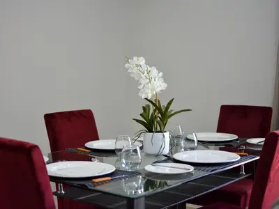 a table with plates and glasses and a vase with flowers at The Pickle Residence in Tzaneen