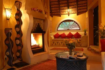 a living room with a fireplace and a couch at Timamoon Lodge in Hazyview