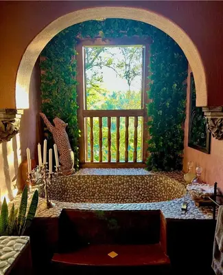 a bathroom with a bath tub with a window at Timamoon Lodge in Hazyview