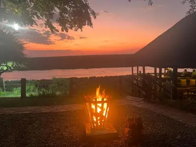a fire pit with a sunset in the background at Crocodile Bridge Safari Lodge in Komatipoort