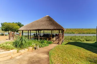 a gazebo with a grass roof on a field at Crocodile Bridge Safari Lodge in Komatipoort