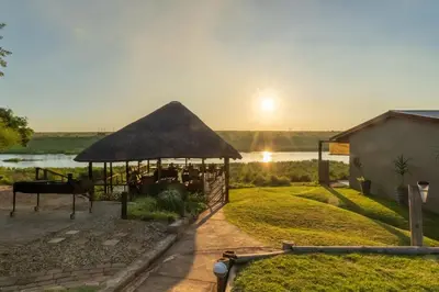 a gazebo with a table and a sunset at Crocodile Bridge Safari Lodge in Komatipoort