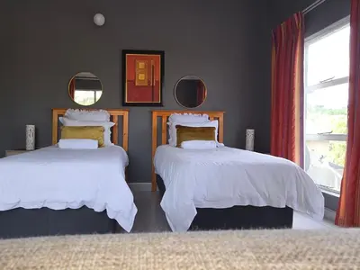 a bedroom with two beds and a window at The Calm Views Holiday Home in Hazyview